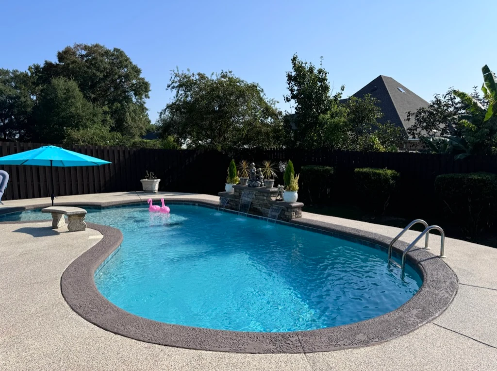 Finished outdoor surface beside a blue swimming pool