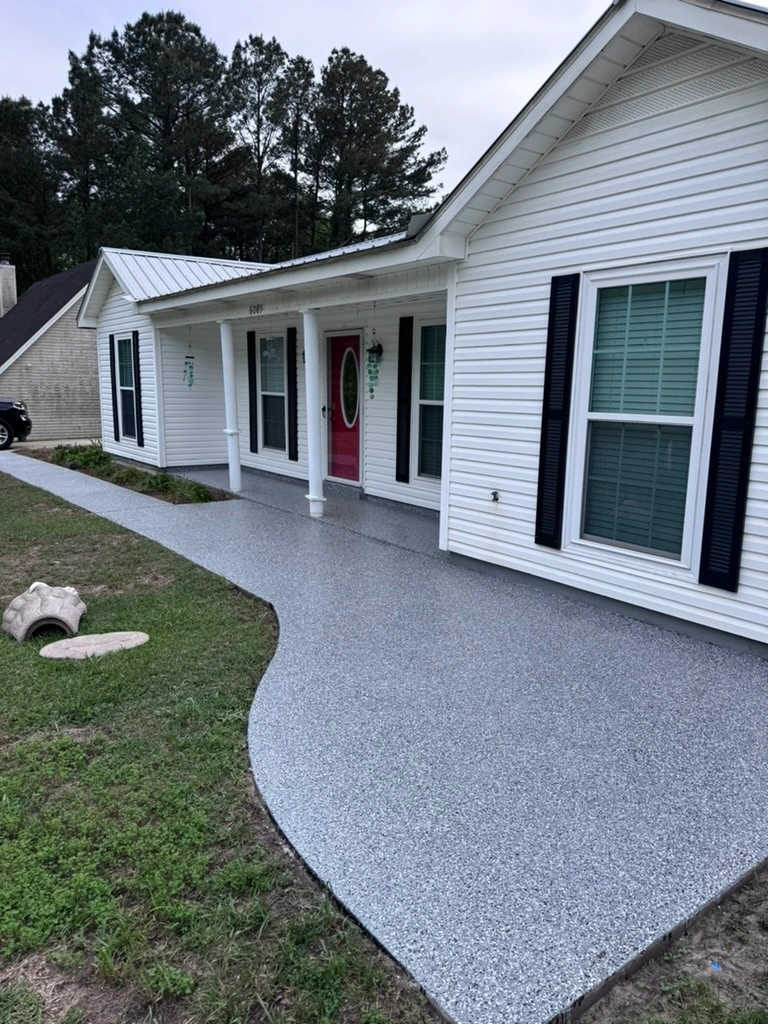 Gray flake coating across a front porch and curved walkway at a white home