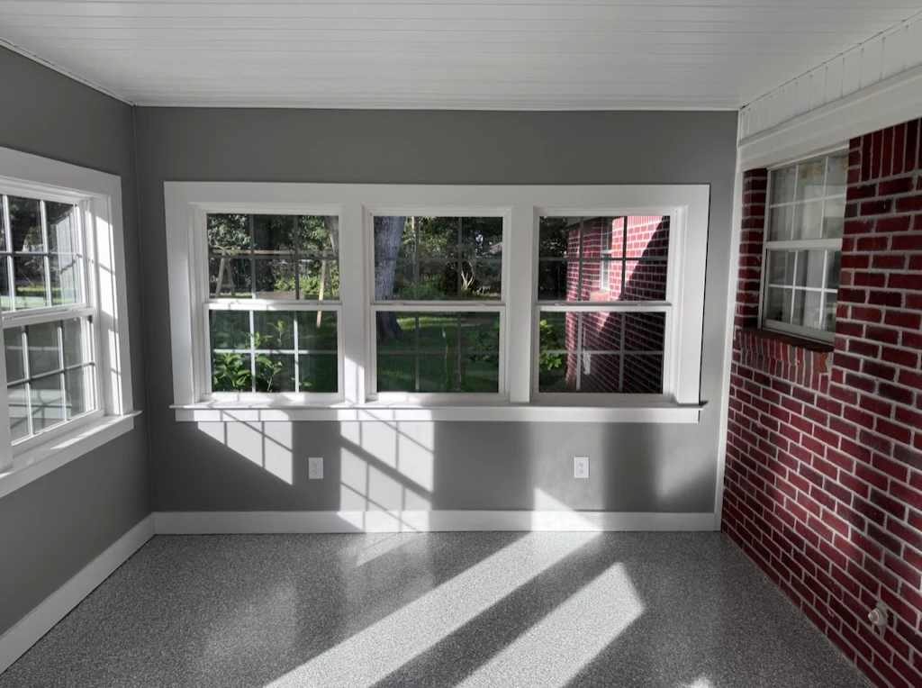 Sunlight across the finished floor of a window-lined sunroom